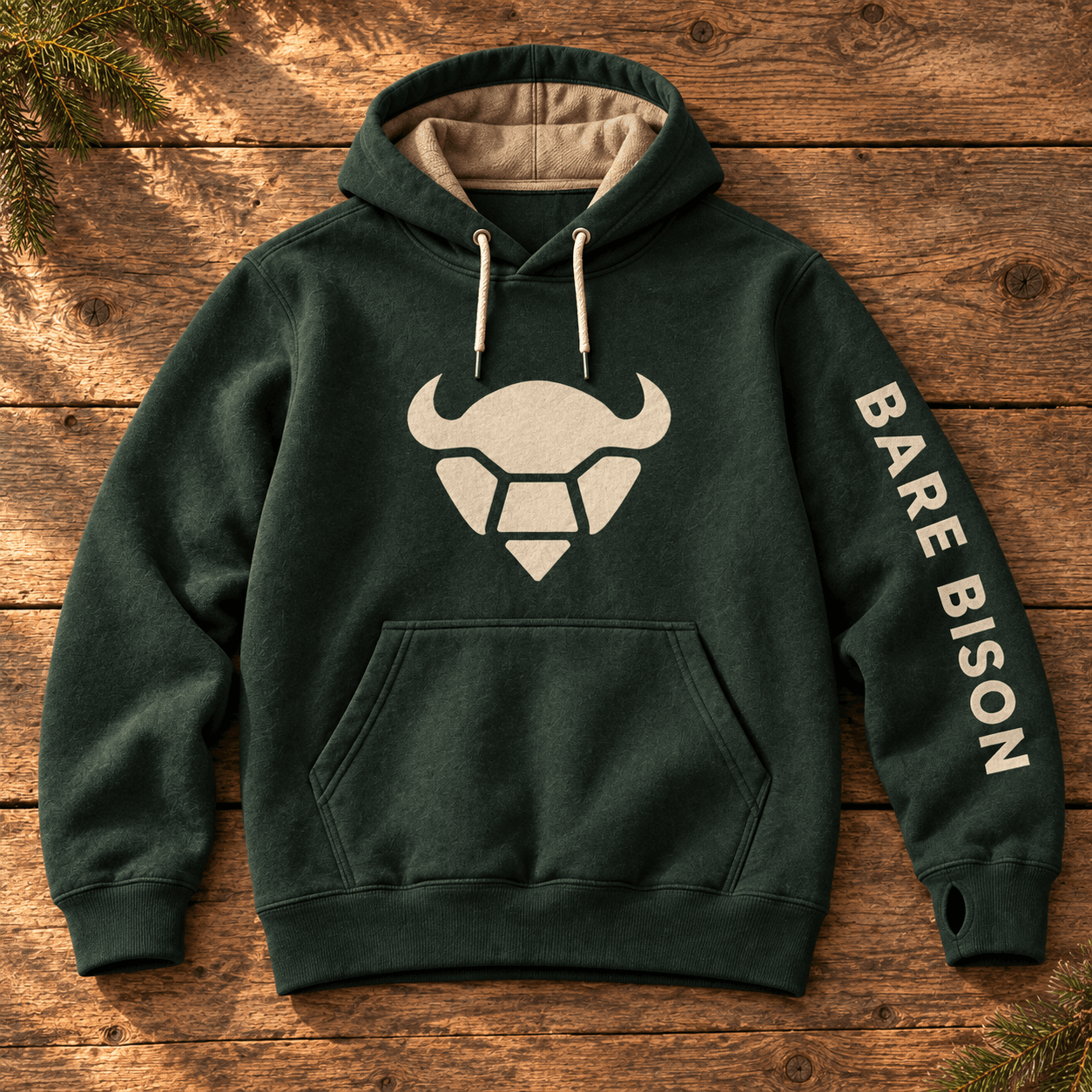 Full forest-green hoodie concept with the selected cream bison head on its chest and Bare Bison lettering down the sleeve